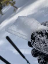 A broken piece of crust with about an inch of soft snow on top. 