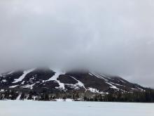 Looking across Red Lake at Red Lake Peak obscured by clouds.