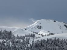 Plumes of blowing snow visible from surrounding peaks in the morning